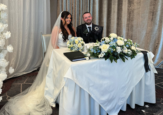 Bride and groom smile at table after signing marriage license